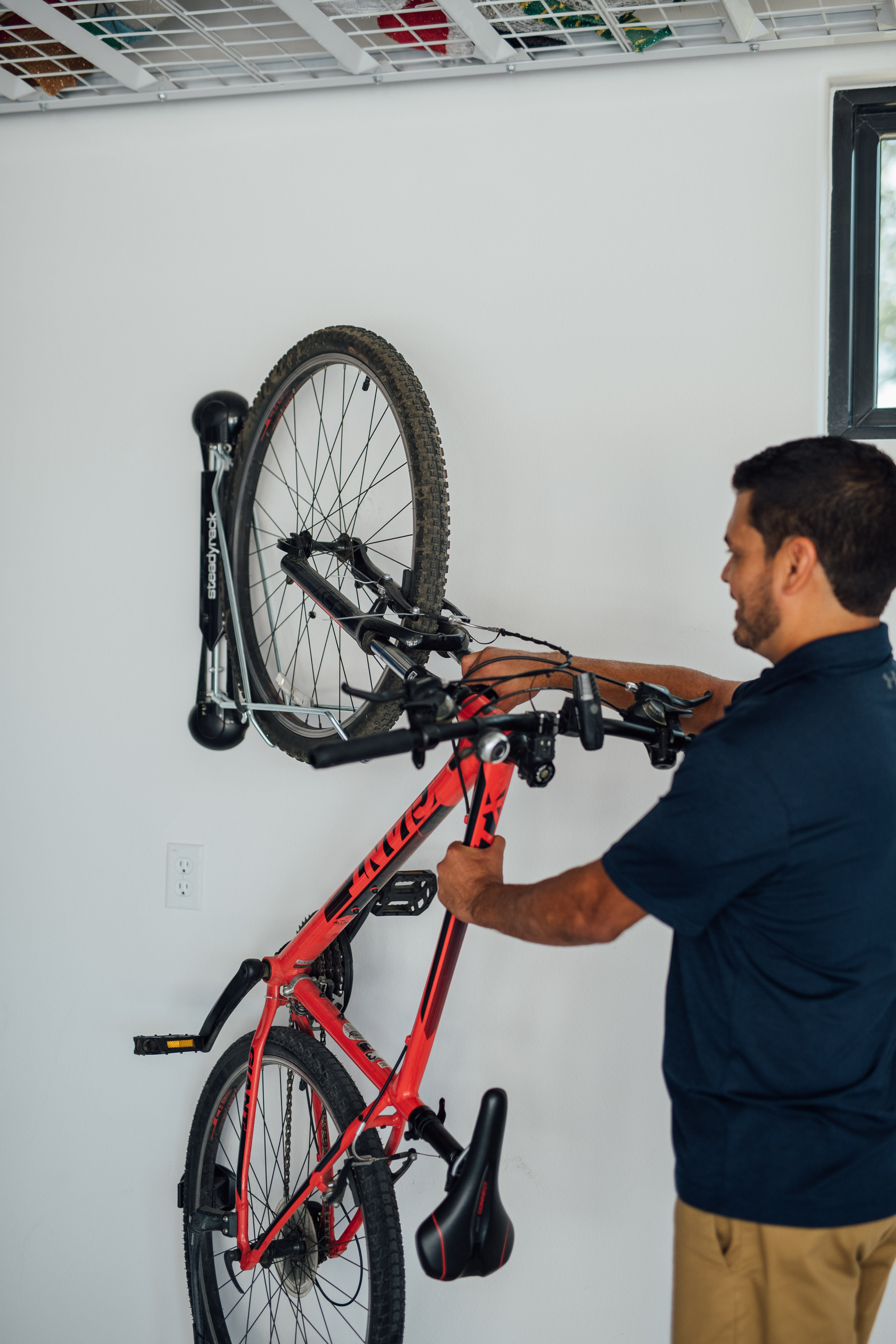 man hanging a bike on a bike rack